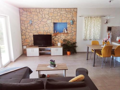 - un salon avec un canapé et une télévision murale dans l'établissement Vacation house Ulika, à Gabonjin