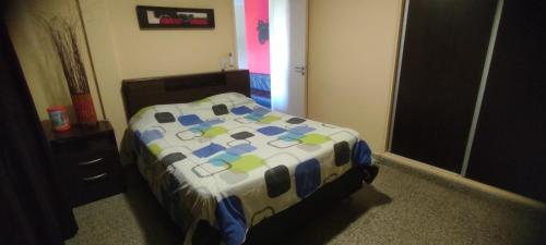 1 dormitorio con cama con edredón en 76 Arruabarrena en Villa Carlos Paz