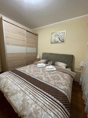 a bedroom with a large bed with two towels on it at Apartman DreamHome in Vrnjačka Banja