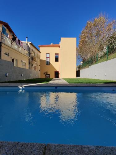 a pool of blue water in front of a building at Cais de Gaia Historic Loft in Vila Nova de Gaia