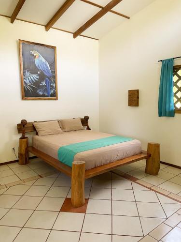 a bed with a wooden frame in a room at Passion Fruit Lodge in Cahuita