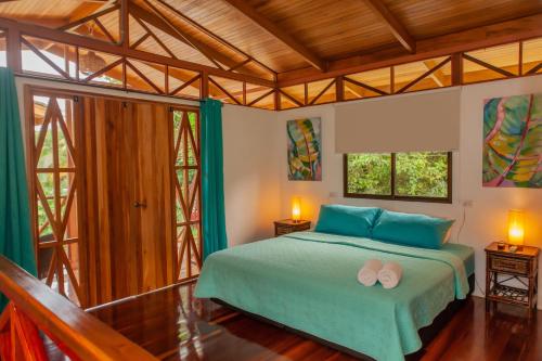 een slaapkamer met een bed met twee slippers erop bij Ibiza Tropical Beach Villas in Uvita
