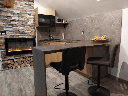 a kitchen with a counter and a fireplace at Apartment Mastnak in Laško