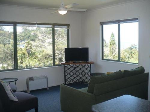 a living room with a couch and a flat screen tv at Whatuwhiwhi TOP 10 Holiday Park in Tokerau Beach
