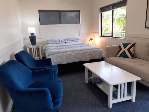 a bedroom with a bed and a chair and a couch at Whatuwhiwhi TOP 10 Holiday Park in Tokerau Beach