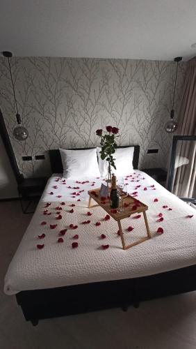 a bedroom with a bed with a table with roses on it at Haarlem Apart Hotel in Haarlem