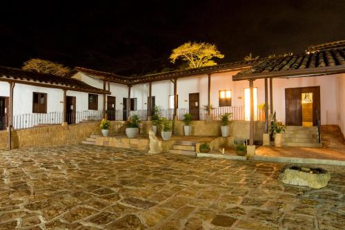 a house with a stone courtyard at night at Don Juan De Dios De Guane Hotel & Centro De Convenciones in Barichara