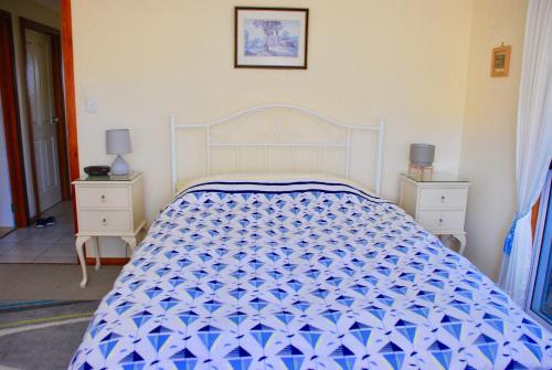 un letto bianco in una camera da letto con due comodini di Annie's Balquhidder Cottage a Victor Harbor
