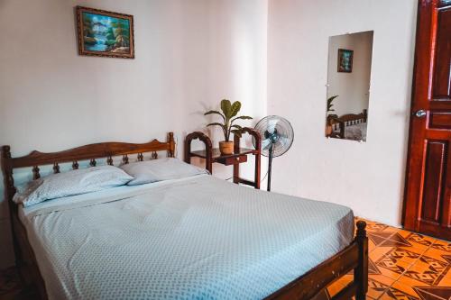 a bedroom with a bed and a fan at Hostal Los Chamos in San Juan del Sur