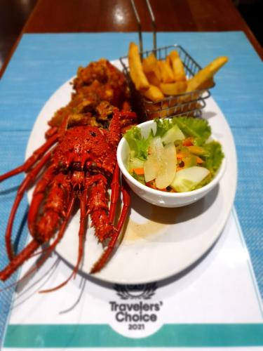 a plate of food with a lobster and a bowl of fries at Rapopo Plantation Resort in Kokopo