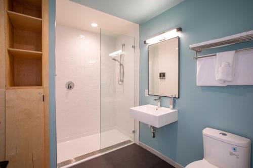 y baño con aseo, lavabo y ducha. en The Monterey Motel, en Albuquerque