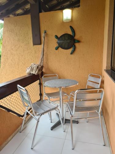 a table and chairs and a bird on the wall at SUMMER HOUSE GENIPABU in Guarajuba