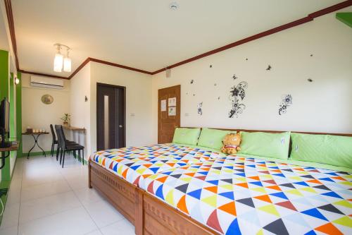 a bedroom with a bed with a teddy bear sitting on it at 田心民宿 in Dongshan