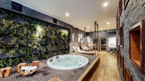 ein Badezimmer mit Whirlpool-Badewanne mit Pflanzenwand in der Unterkunft Parque Pinares 2 dormitorios in Pucón