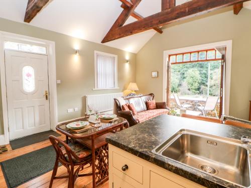 a kitchen with a sink and a living room at Leadmill House Workshop in Copley