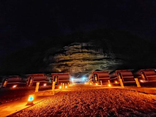 a group of buildings on a beach at night at WADI RUM STAR WARS CAMP in Wadi Rum