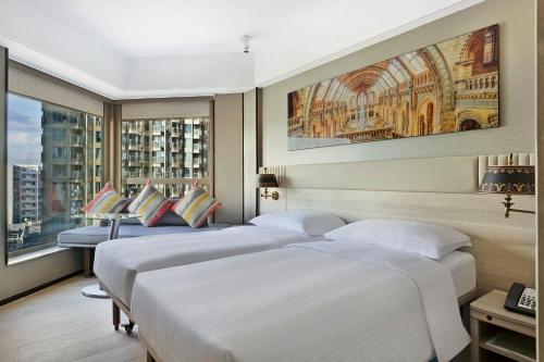 a hotel room with four beds and a window at Hotel Alexandra in Hong Kong