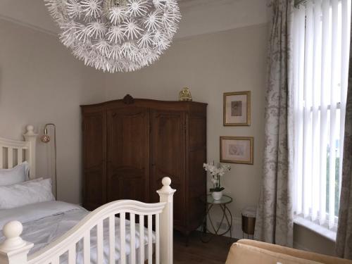 a bedroom with a crib and a chandelier at The Leas View in Folkestone