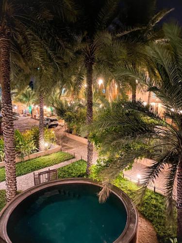 an overhead view of a swimming pool with palm trees at نزل البستان Bustan lnn in Nizwa