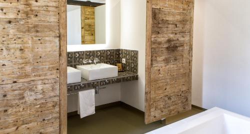 a bathroom with two sinks and a mirror at Hotel Les Chambres de Mila in Bonifacio