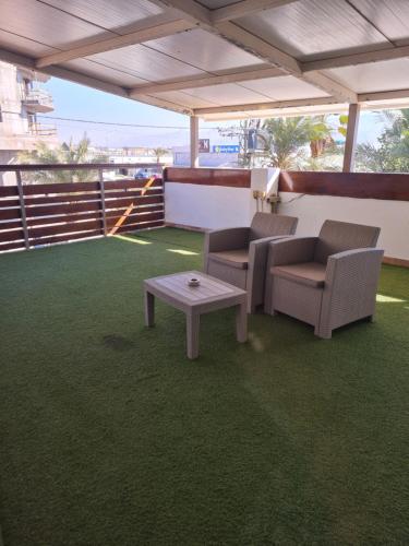 a patio with two chairs and a coffee table at Arava Hostel in Eilat