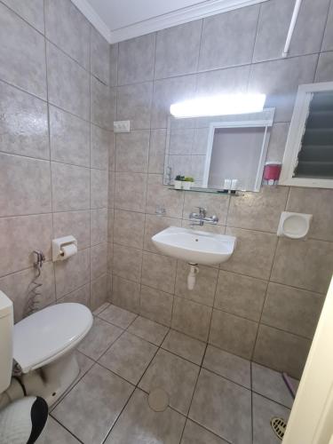 
a bathroom with a toilet, sink, and bathtub at Arava Hostel in Eilat
