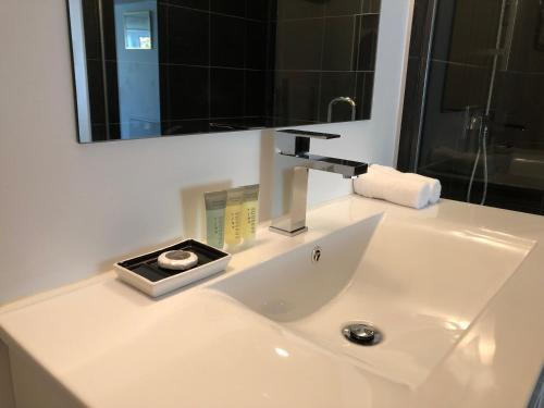 lavabo con grifo y espejo en Greengables B&B en Queenstown
