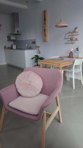 a purple chair with a pillow on it in a kitchen at Het arrangement in Wemeldinge