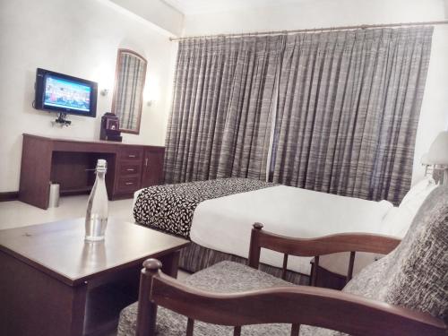 a hotel room with a bed and a table and a tv at Hotel Elite Palazzo in Kāladi