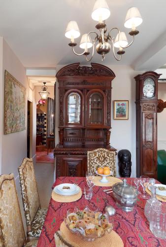 une salle à manger avec une table et une horloge grand-père dans l'établissement Appartements de la Côte, à Beaune