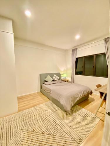 a bedroom with a bed and a rug at Faizal Madhi Homestay in Kuching