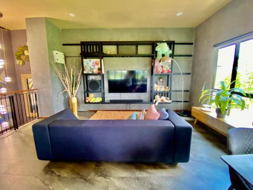 a living room with a blue couch and a tv at Faizal Madhi Homestay in Kuching