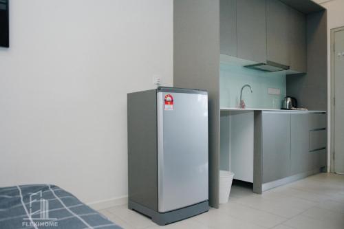 a kitchen with a refrigerator in the corner of a room at 9am-5pm, SAME DAY CHECK IN AND CHECK OUT, Work from Home, Comfy & Quiet Tamarind Suites-Cyberjaya by Flexihome-MY, in Cyberjaya