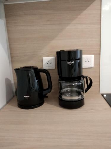 two black coffee pots sitting on a counter at T2 - 2 à 3 personnes Tout équipé in Lorette