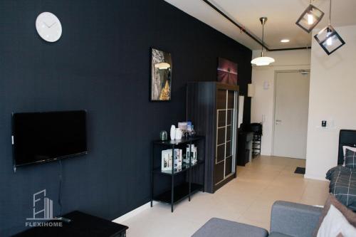 a living room with a flat screen tv on a wall at 9am-5pm, SAME DAY CHECK IN AND CHECK OUT, Work from Home, Comfy & Quiet Tamarind Suites-Cyberjaya by Flexihome-MY, in Cyberjaya