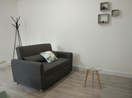 a living room with a couch and a table at T2 - 2 à 3 personnes - draps et serviettes en option in Lorette