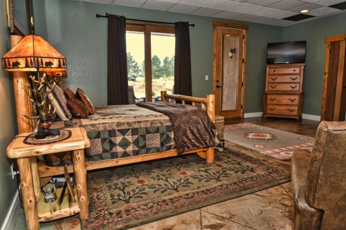 1 dormitorio con 1 cama y 1 mesa con lámpara en Rampart Range Resort en Woodland Park
