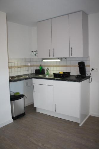 a kitchen with white cabinets and a counter top at Schönes Zimmer mit Bad für Reisende in Murg