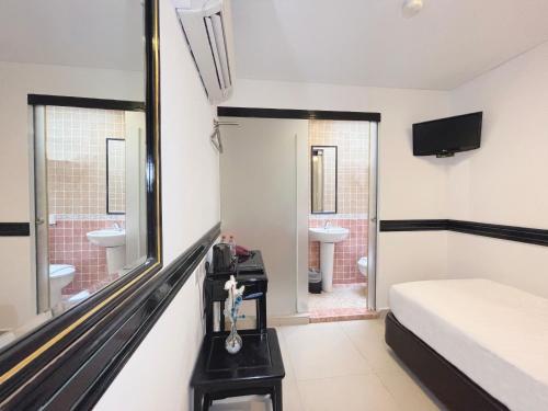 a bedroom with a bed and a mirror and a sink at The Snooze Hotel Marine Parade in Singapore