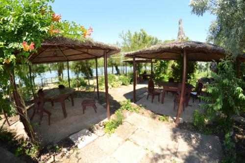 un patio con 2 sombrillas, mesas y sillas en Complex Amazon, en Neptun
