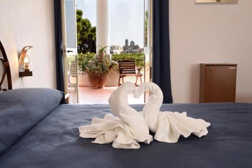 two white swans making a heart on a bed at Gattopardo Park Hotel in Lipari