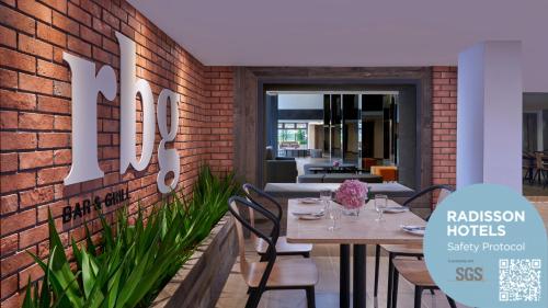 a restaurant with a brick wall with a table and chairs at Park Inn by Radisson Putrajaya in Putrajaya