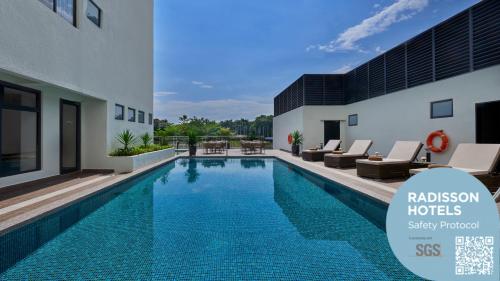 una piscina di fronte a un edificio di Park Inn by Radisson Putrajaya a Putrajaya
