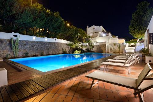 a swimming pool at night with chairs around it at Gattopardo Park Hotel in Lipari
