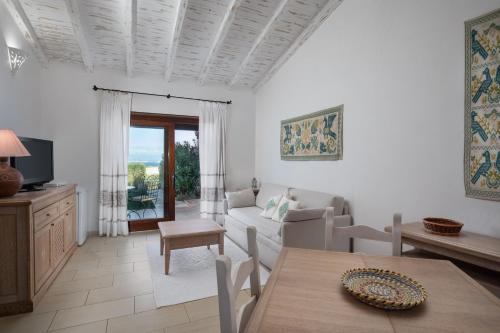 uma sala de estar com um sofá e uma mesa em Punta Falcone Resort em Santa Teresa Gallura