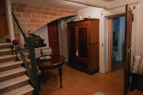 Habitación con escalera, mesa y pared de ladrillo. en La Quercia In Giardino, en Ducato di Fabriago