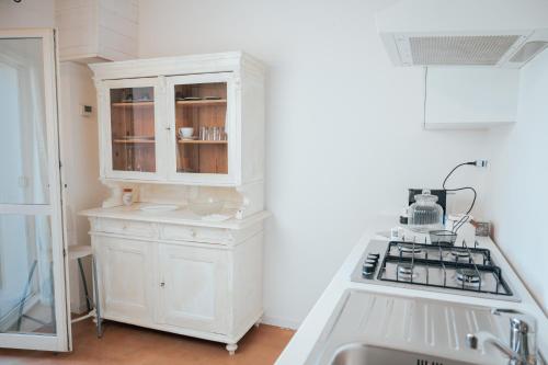 cocina con armario blanco y fogones en La Quercia In Giardino, en Ducato di Fabriago