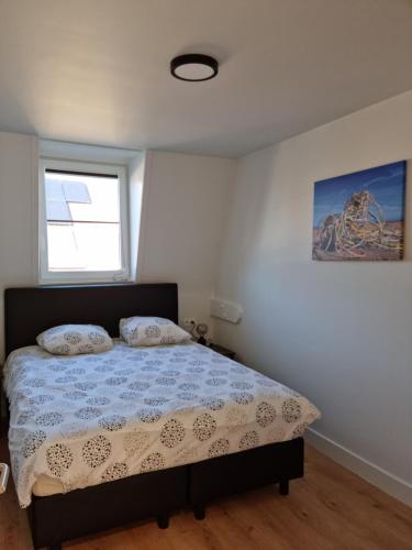 a bedroom with a bed and a window at Maison Florimond in Nieuwpoort