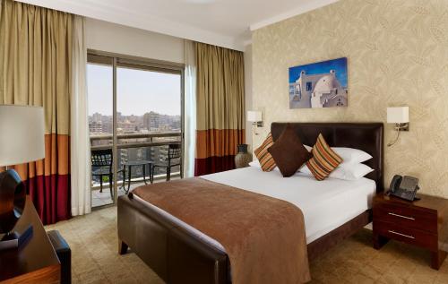 a hotel room with a large bed and a balcony at Staybridge Suites & Apartments - Citystars, an IHG Hotel in Cairo