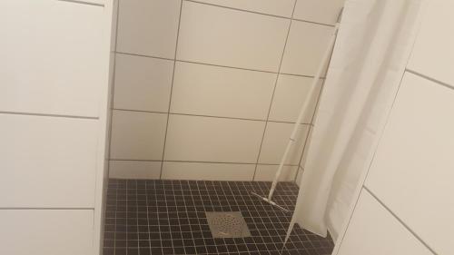 a bathroom with a shower with a tile floor at SJÖTORPS HOSTEL in Sjötorp